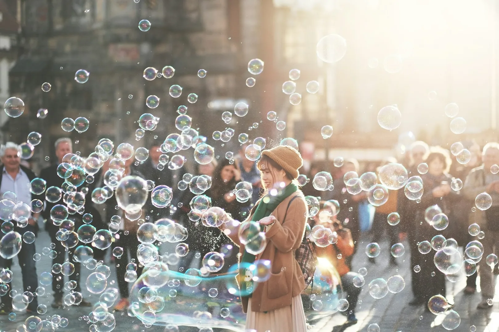 A person surrounded by soap bubbles in a street.