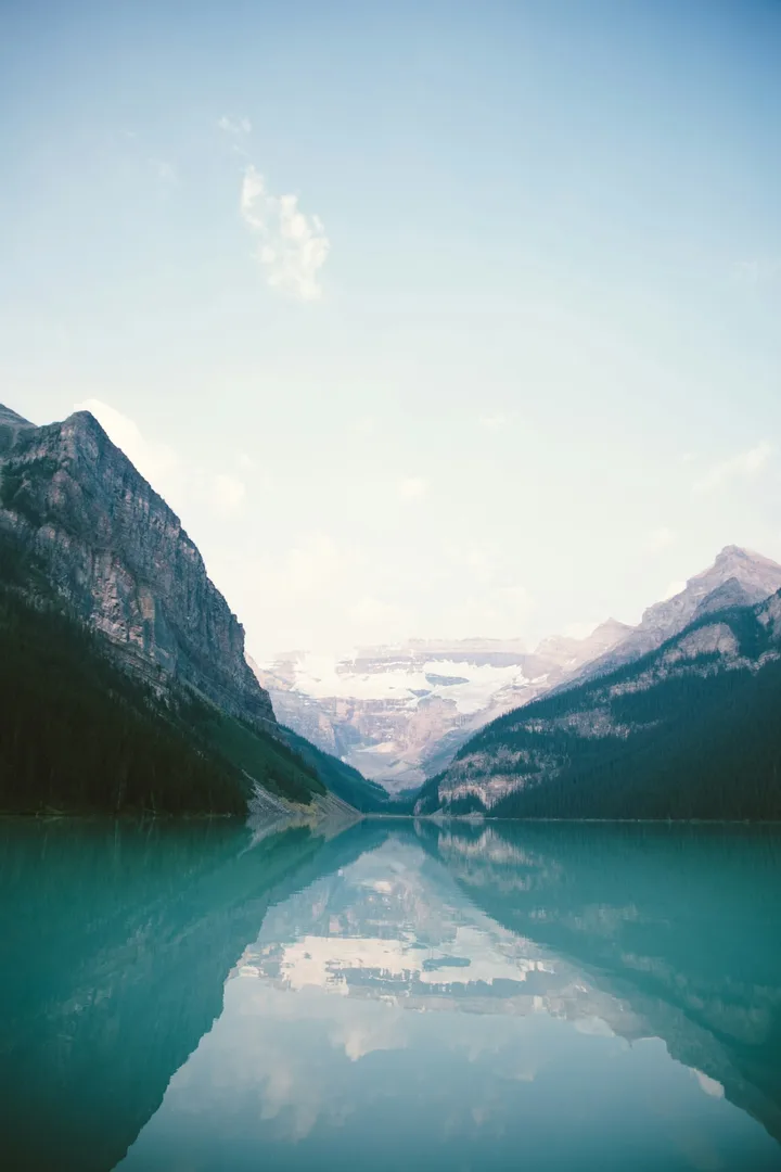 A mountain lake between two snow-covered slopes.