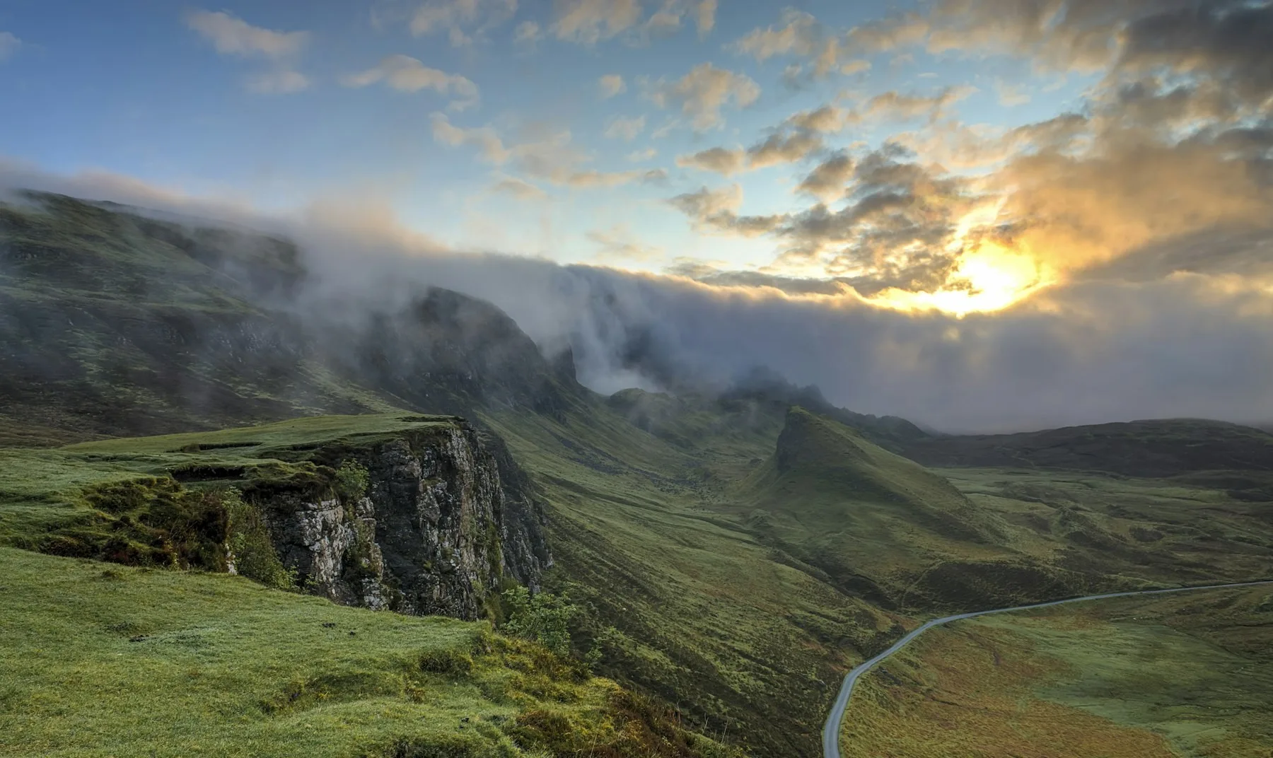 A mountain road disappearing into low cloud.