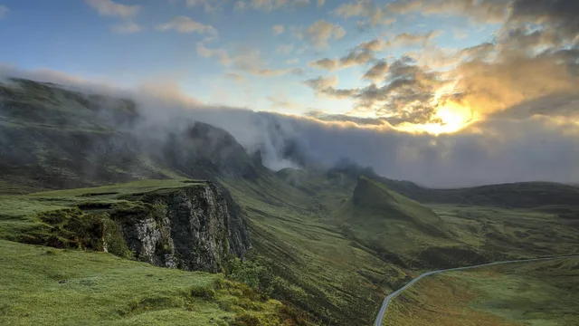 A mountain road disappearing into low cloud.