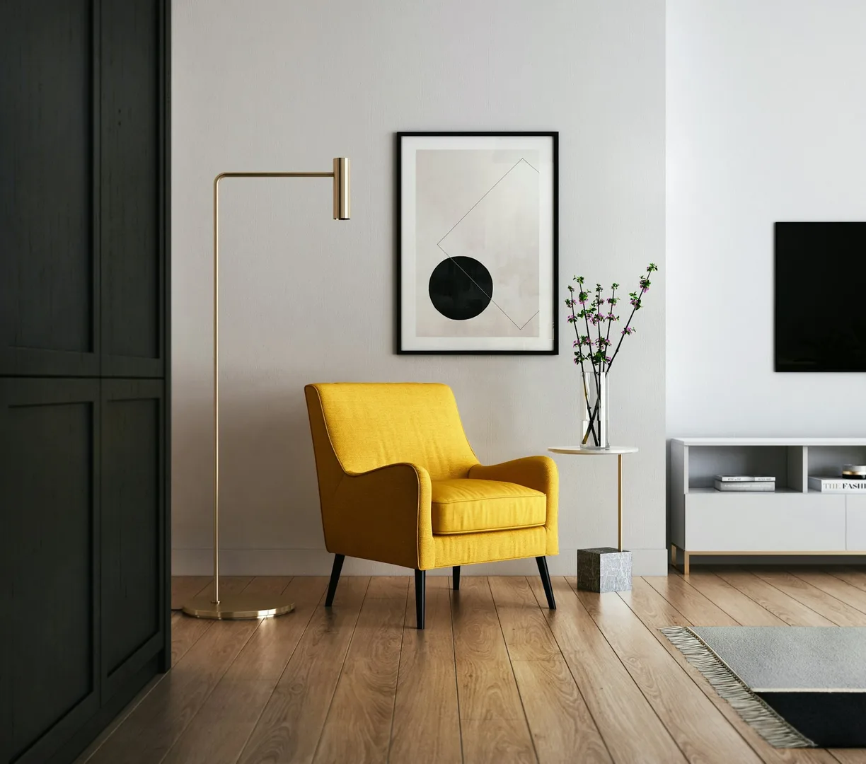 A yellow armchair beside a floor lamp and a framed print.