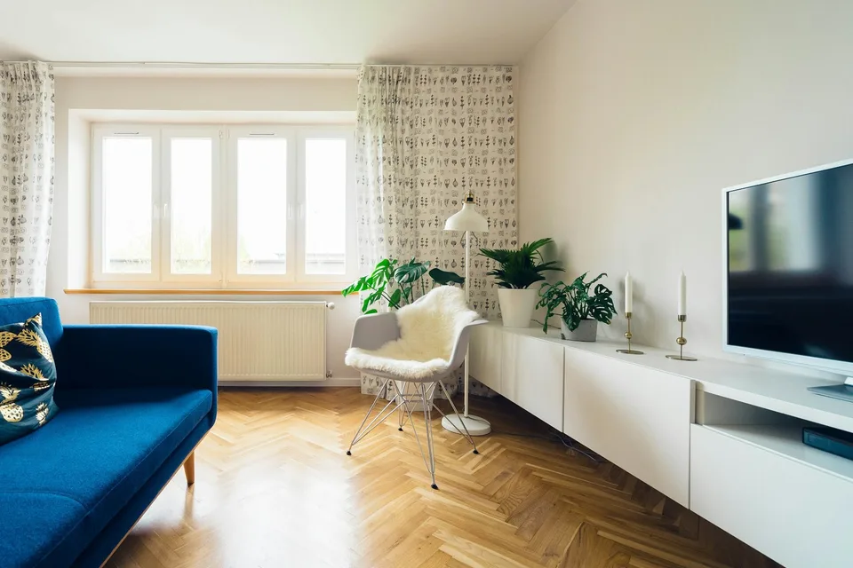 A sitting room with herringbone parquet and tall windows.