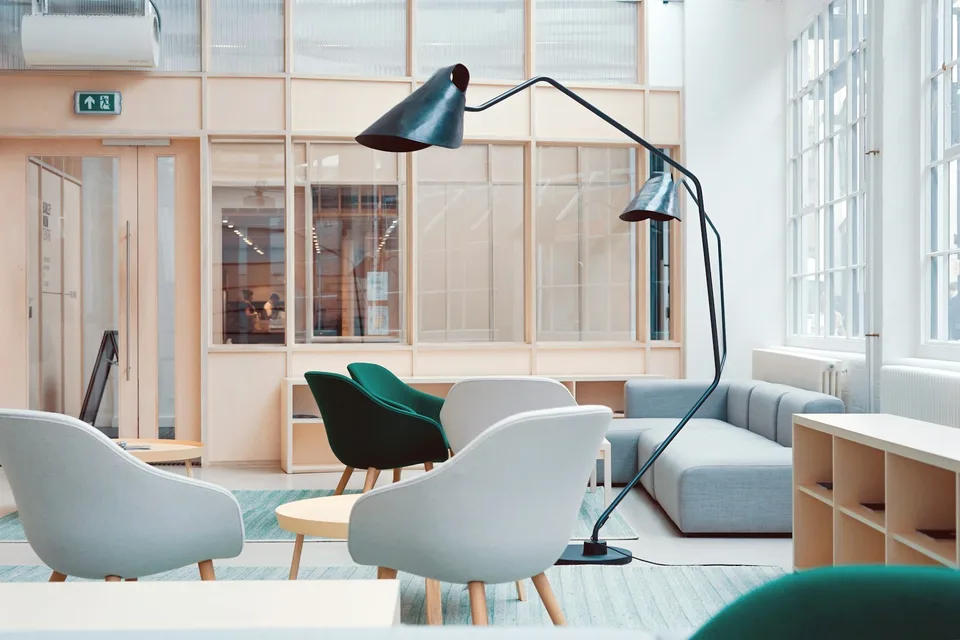 A waiting area with pale armchairs and an arc lamp.